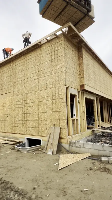 Setting roof trusses by crane on a new custom home in Troy MI