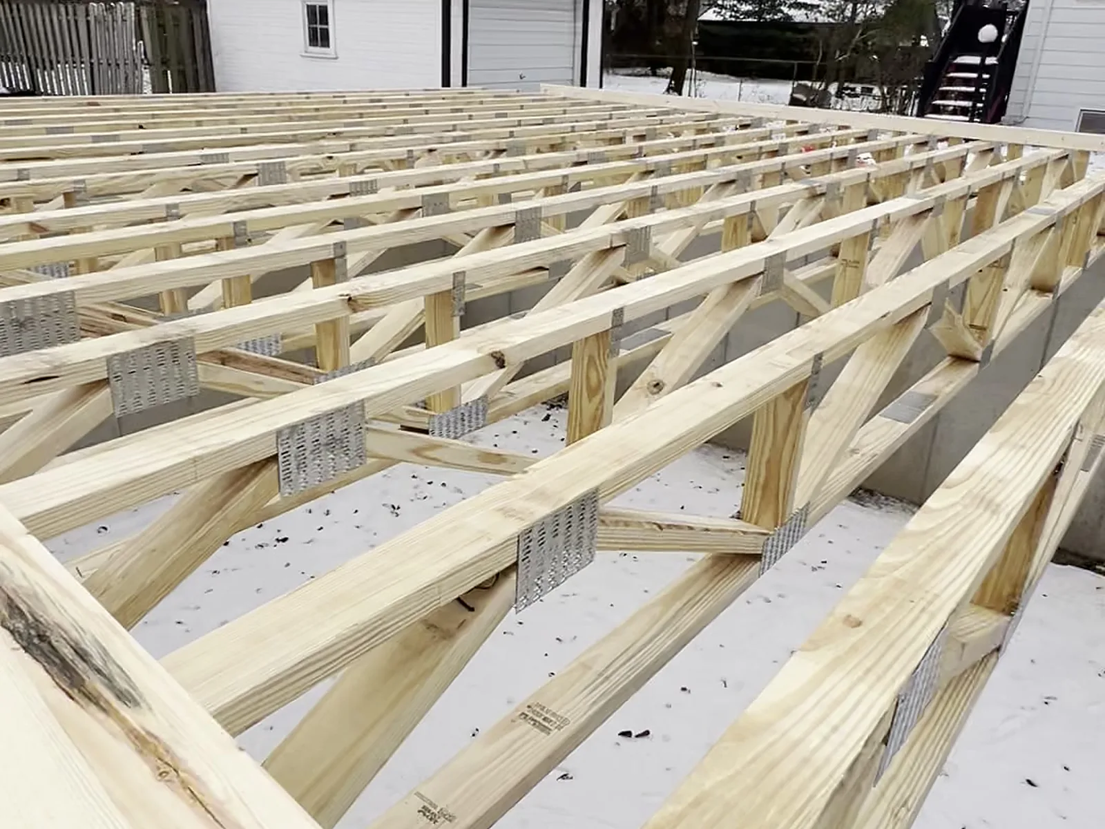 Open web floor trusses set on the foundation, winter build, Clawson MI