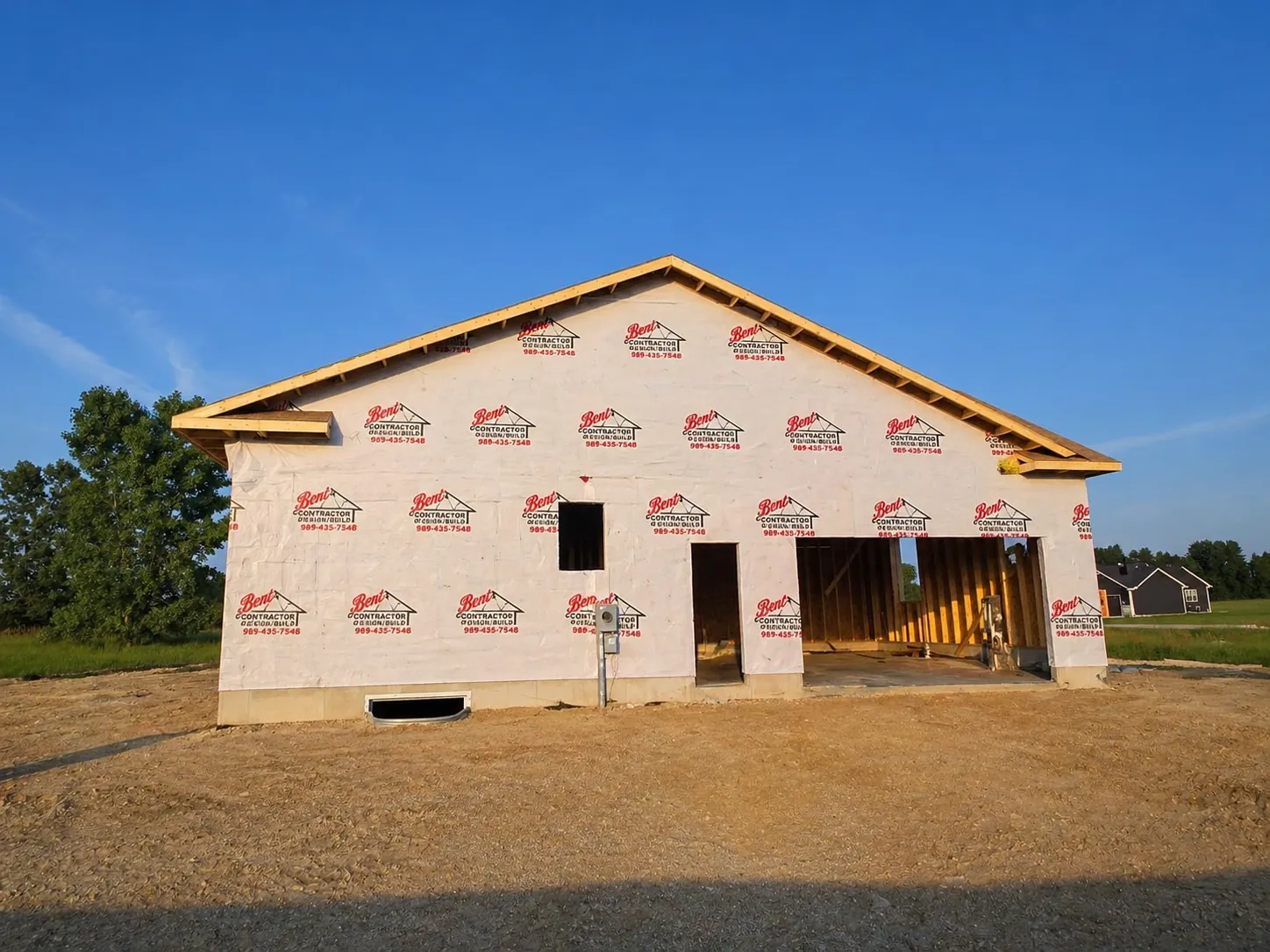 Gable end of a new home framed, sheathed and house-wrapped, ready for roofing