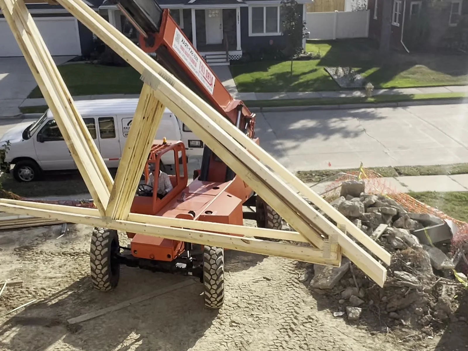Roof truss lifted into place by telehandler
