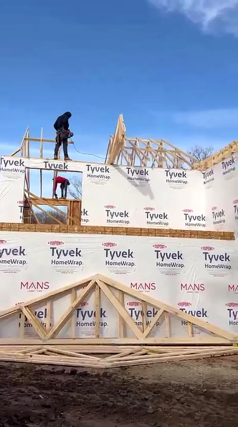 Crew setting roof trusses on a house wrapped two story home, Novi MI