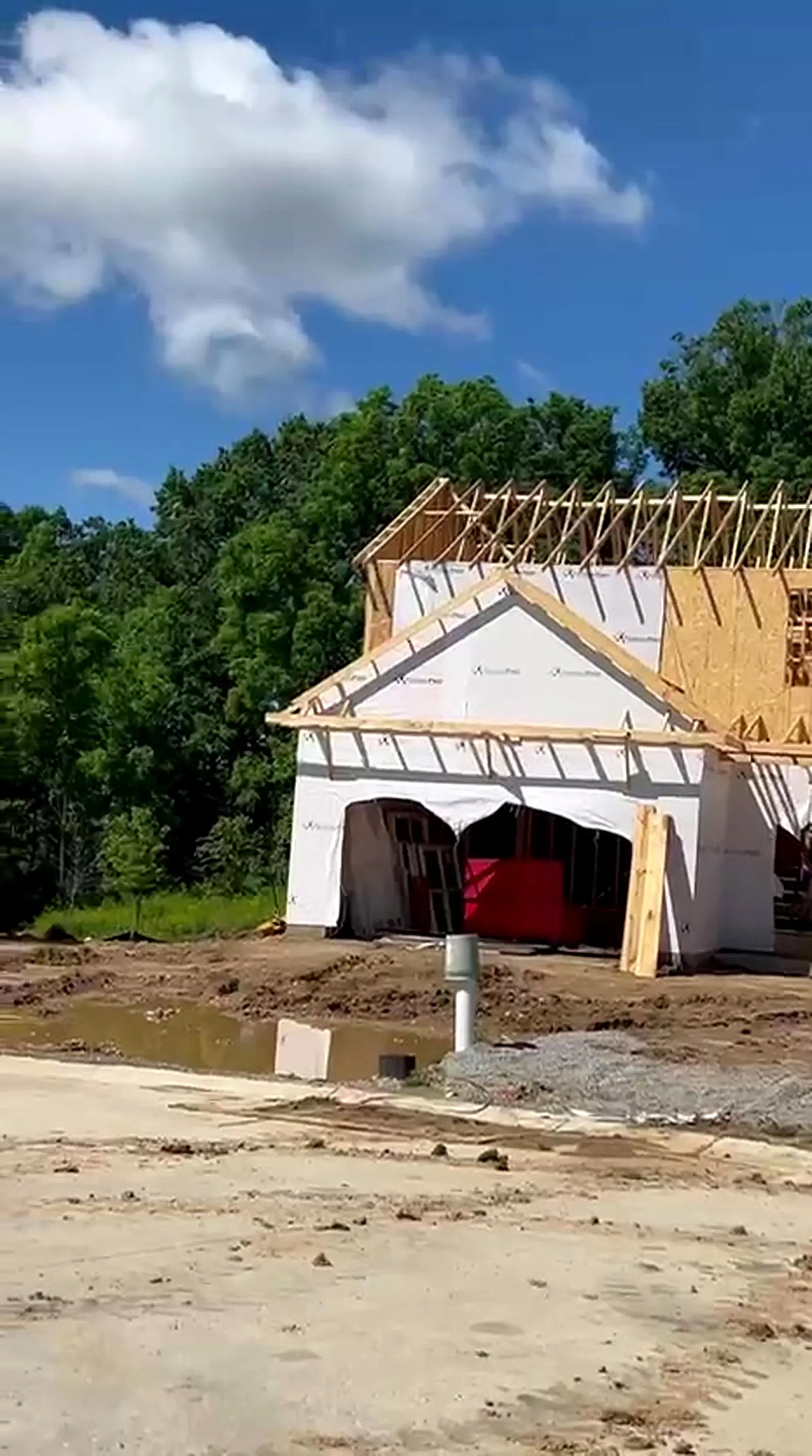 New home with gable and roof trusses framed against a blue sky, Whitmore Lake MI